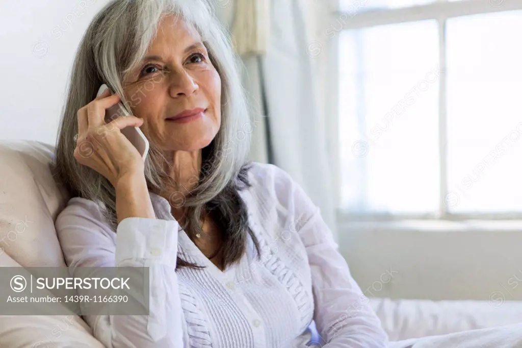 Portrait of attractive senior woman chatting on smartphone