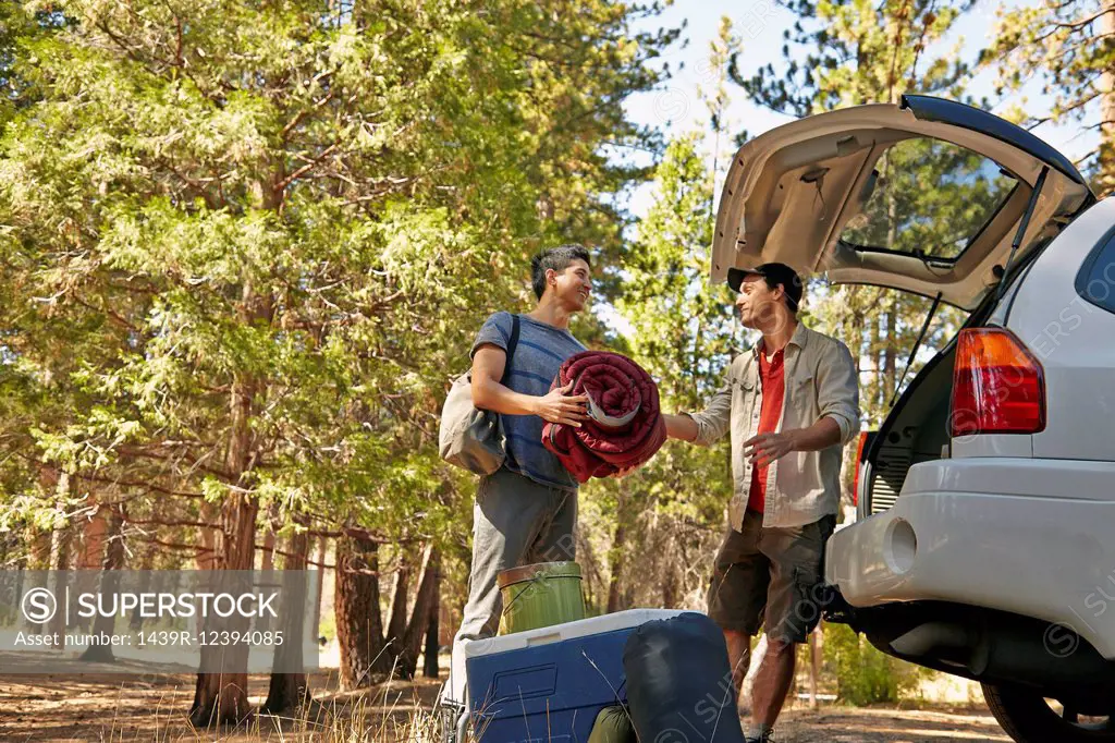 Two young male campers unpacking car boot in forest, Los Angeles, California, USA