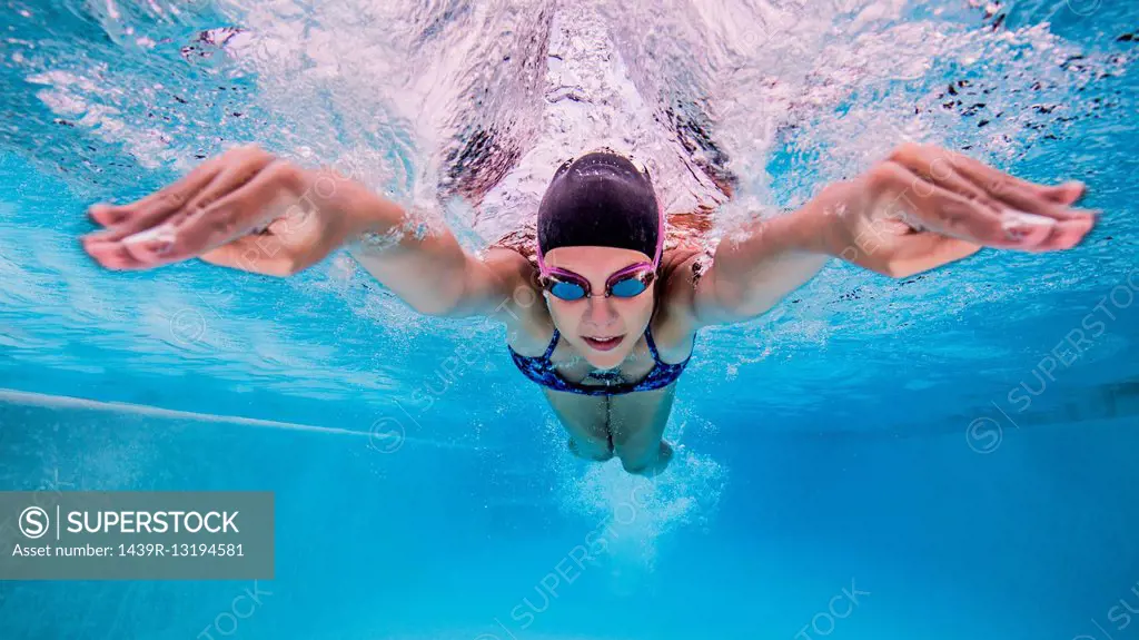Underwater view of teenage girl swimming in pool
