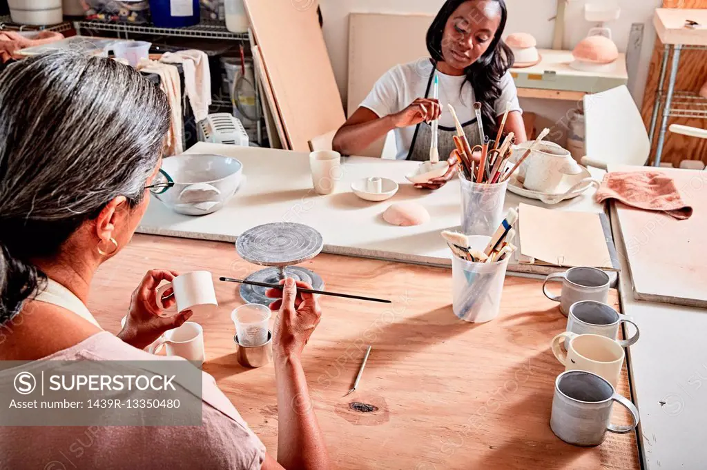 Potters in workshop painting pottery