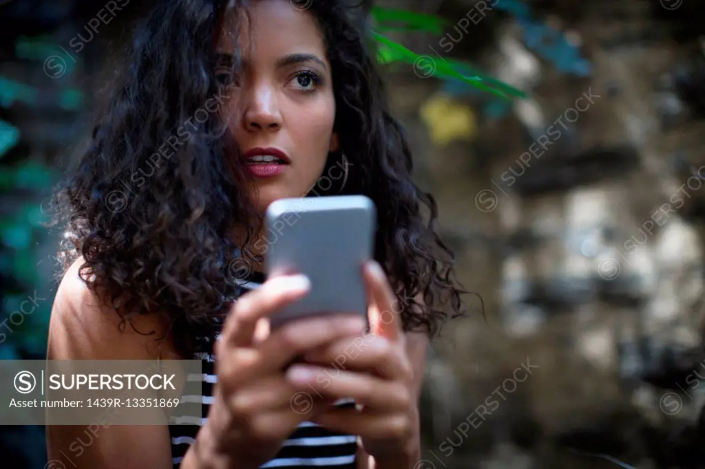 Young woman outdoors, using smartphone