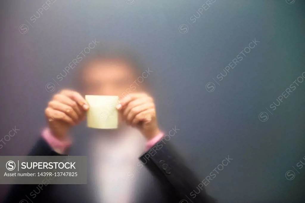 Man sticking note on frosted screen