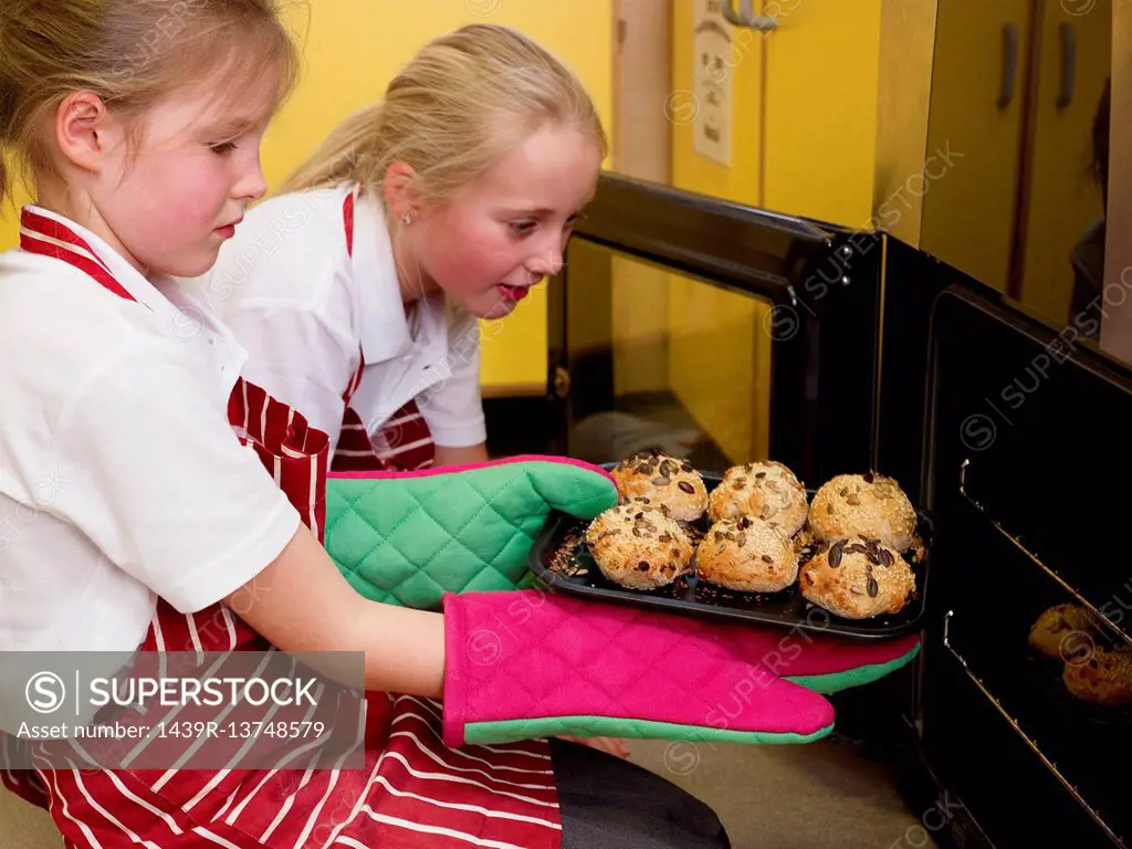 girls taking bread out of the oven