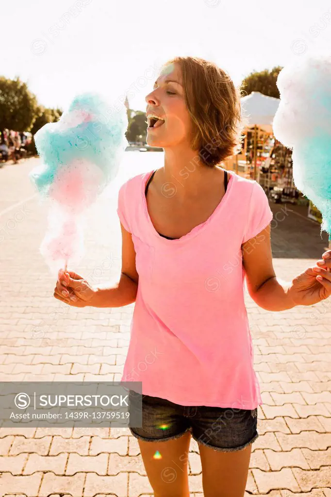 Woman eating cotton candy outdoors