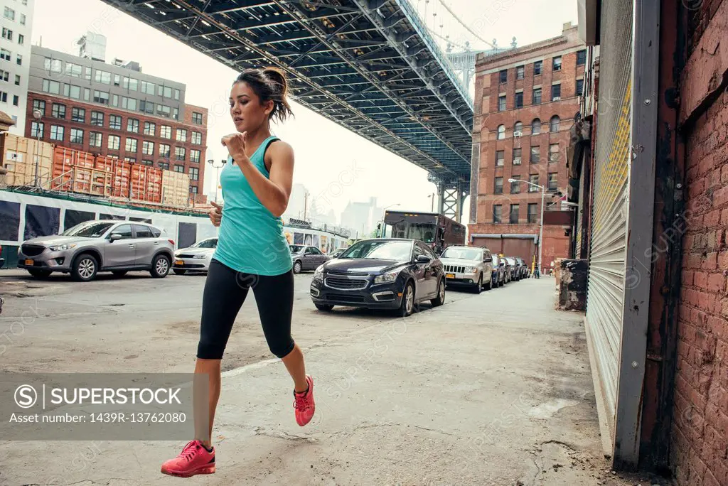 Young female runner running, New York, USA