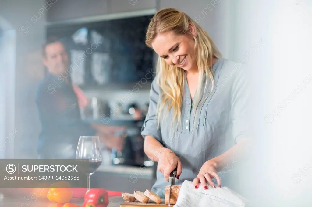 Woman slicing bread on kitchen counter