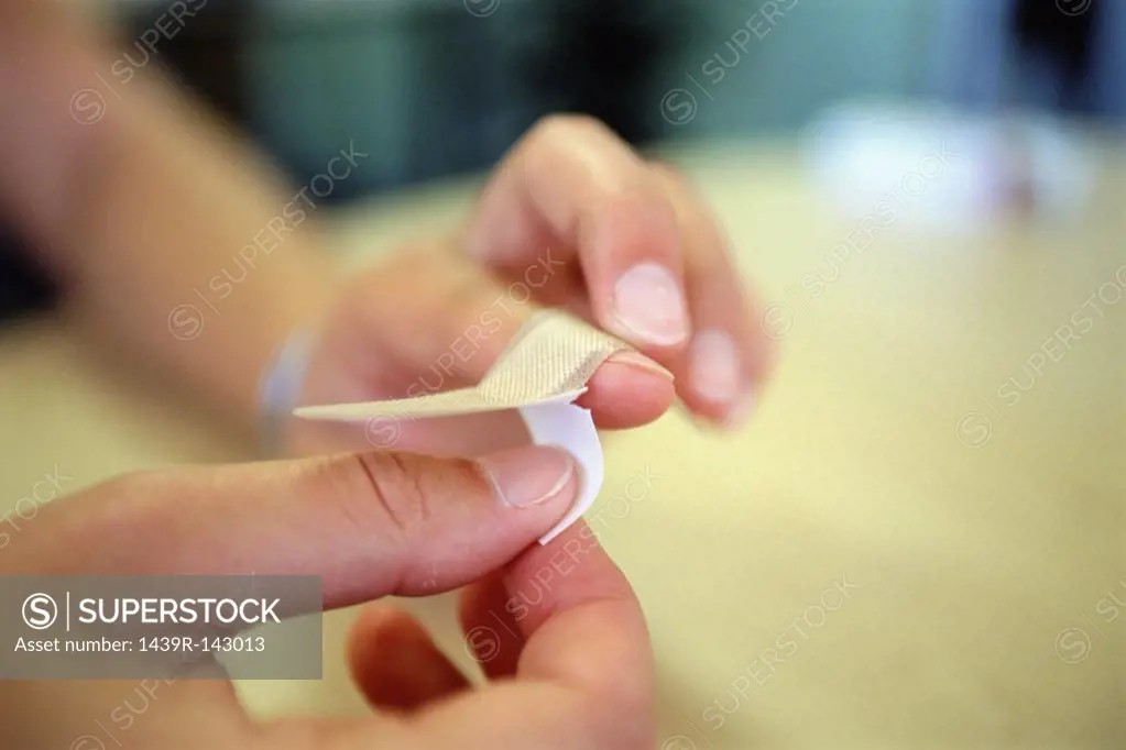 Applying plaster on finger
