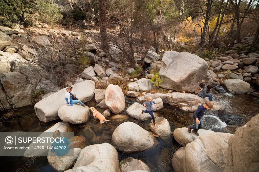 Family playing on rocks in river, Lake Arrowhead, California, USA