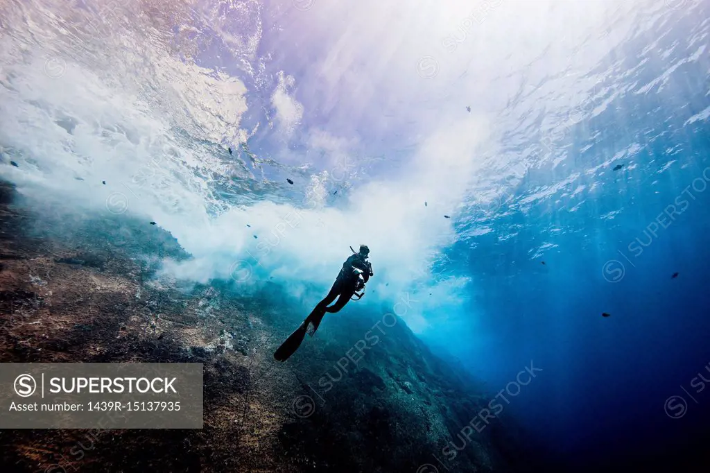 Underwater view of female diver exploring roca partida pinnacle, Socorro, Baja California, Mexico
