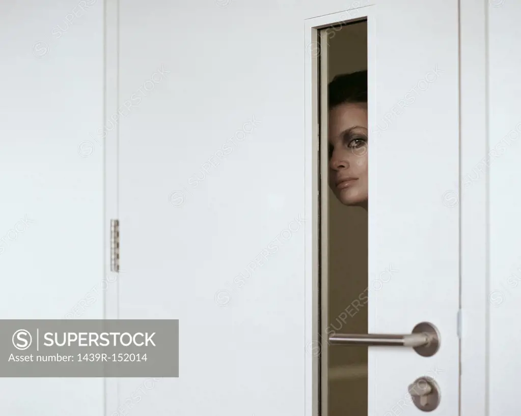 Woman peering through door
