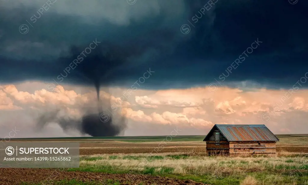 Landspout-tornado hybrid on plains, barn in foreground, Cope, Eastern Colorado, US