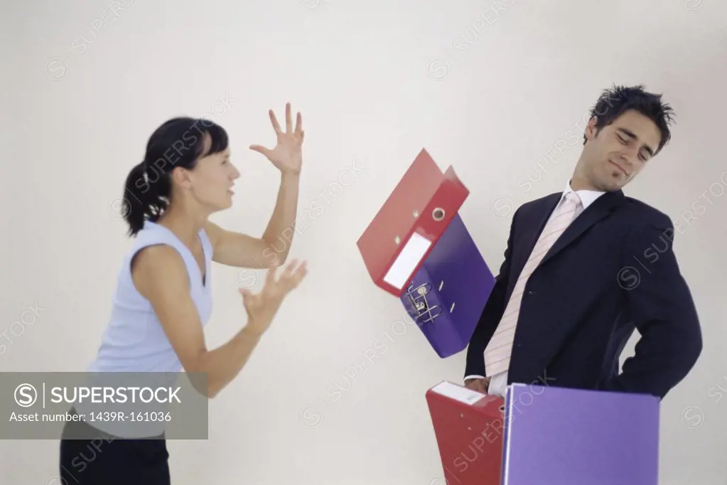 Woman throwing folders at man