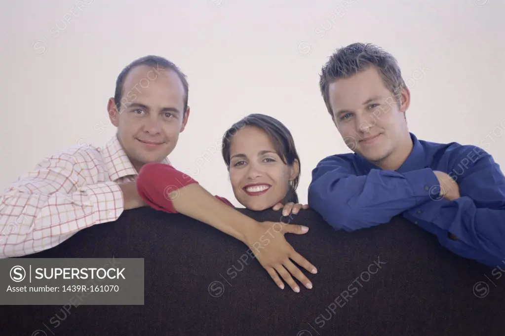 Three colleagues leaning on a divider