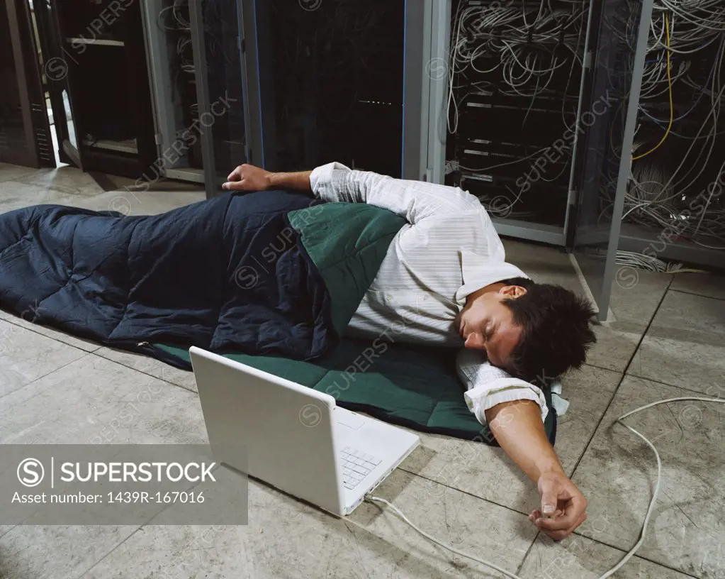 Man sleeping next to laptop