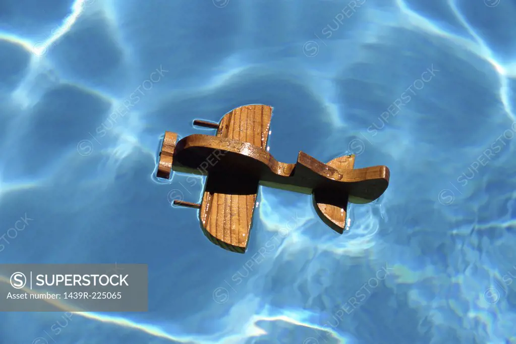 A wooden aircraft on a swimming pool