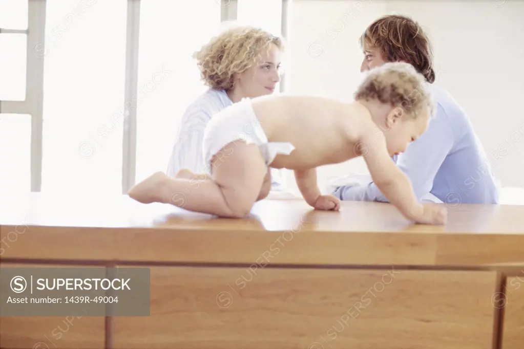 Baby crawling with parents