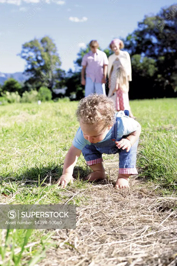 Curious toddler with family in the background