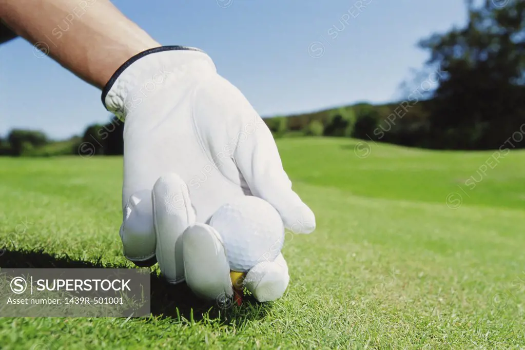 Gloved hand with golf ball