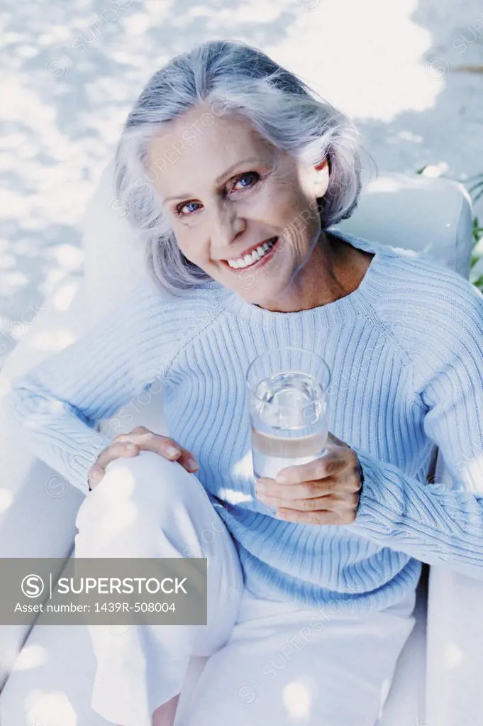 Ageing woman drinking outdoors