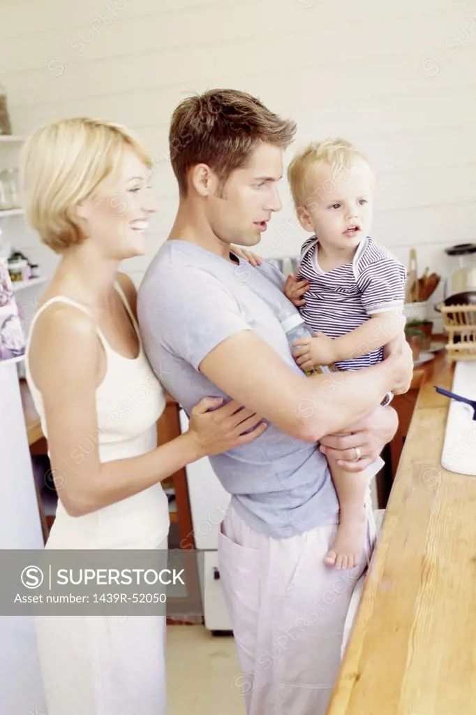 Young parents with child in the kitchen