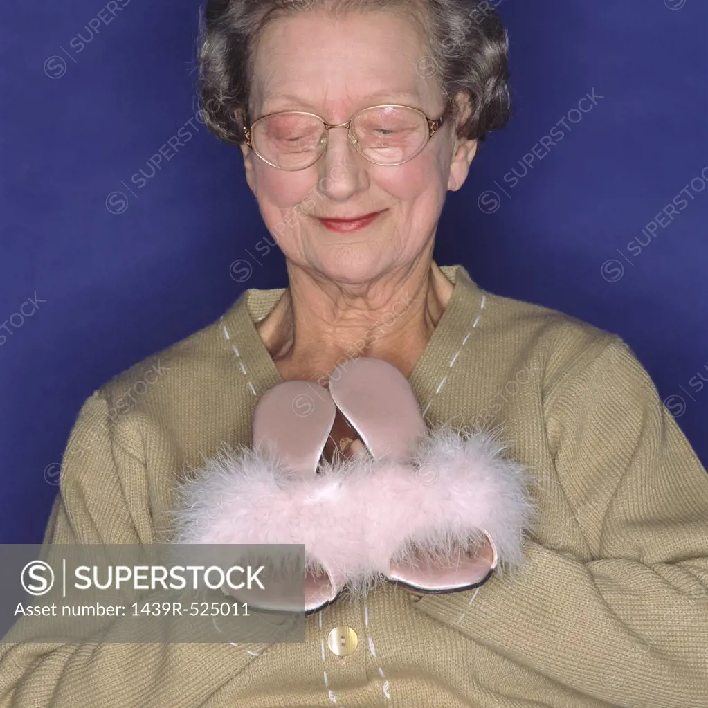 Senior woman holding sexy slippers 