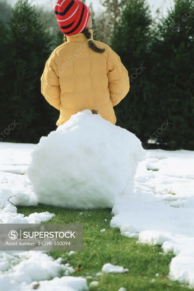 Girl sitting on a big snowball