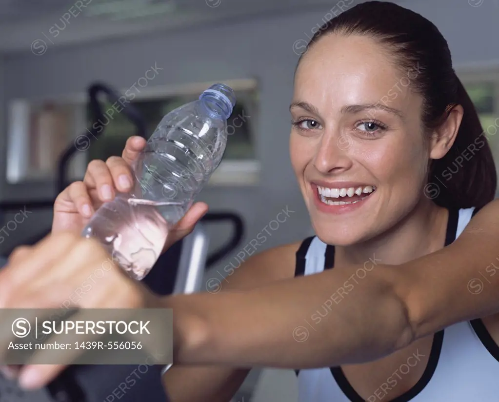 Woman drinking water in a gymnasium