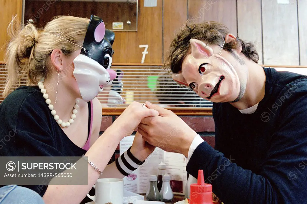 Couple wearing face masks in cafe