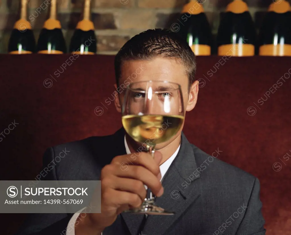 Man holding wine glass in front of his face
