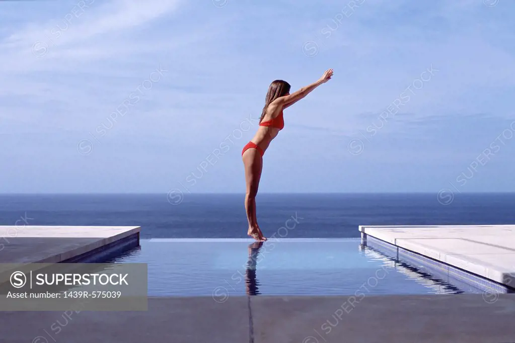 Young woman at swimming pool by the sea