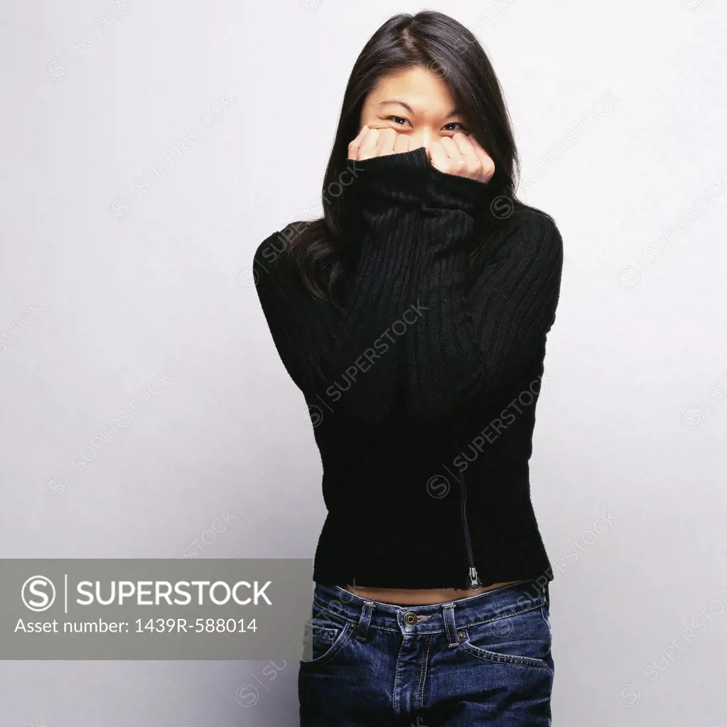 Woman covering face with sweater