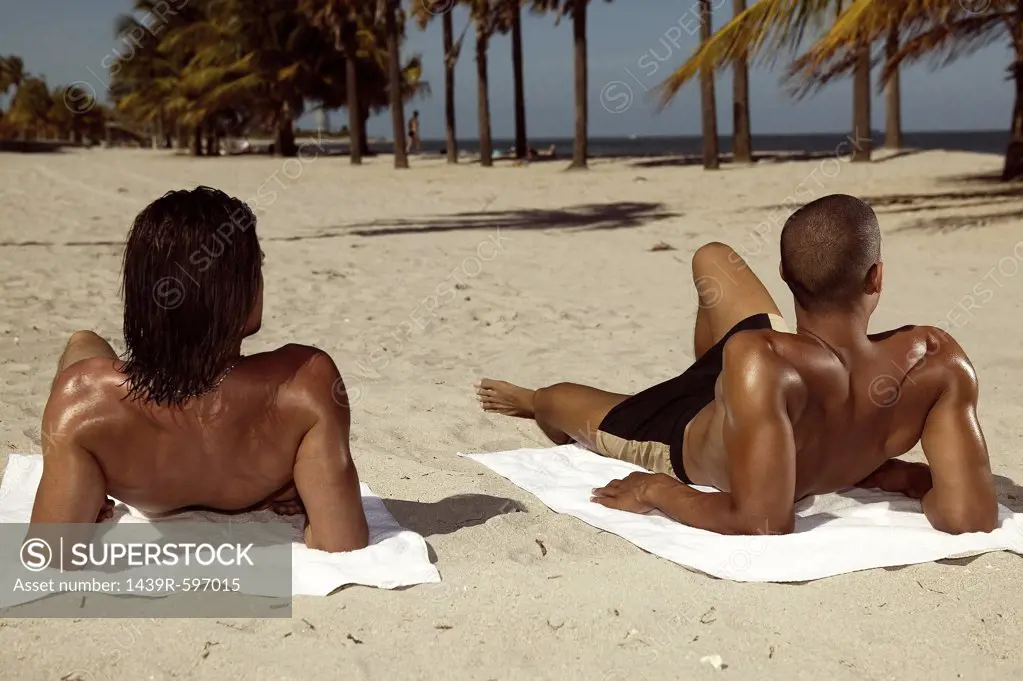 Men sunbathing on beach