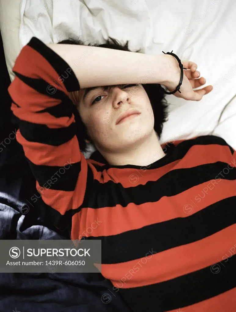 Teenage boy lying on bed