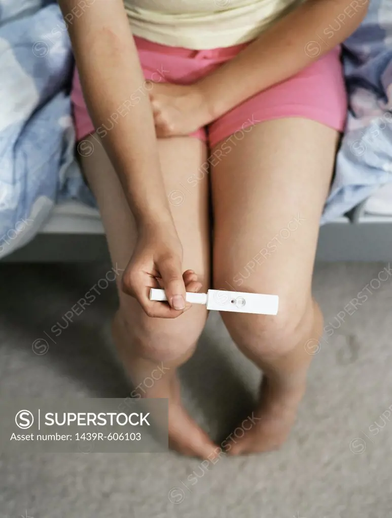Teenage girl holding pregnancy test