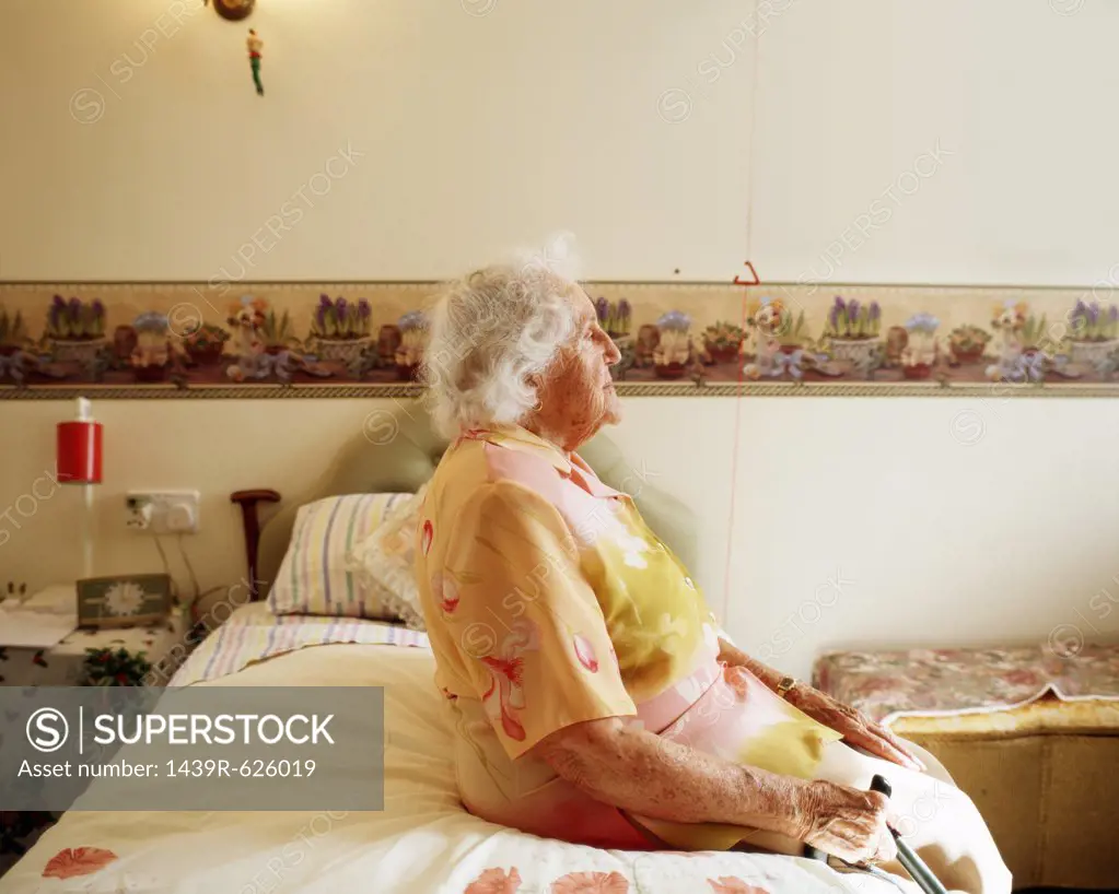 Elderly woman sitting on her bed 