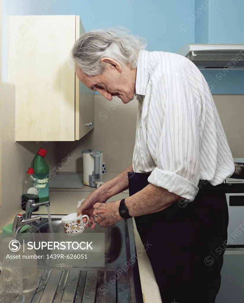 Elderly man washing up