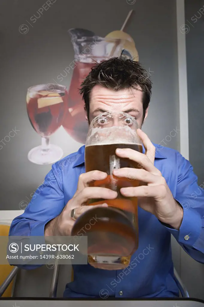 Man drinking beer from glass boot