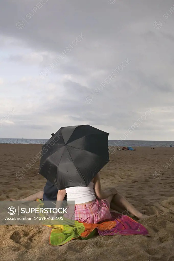 Couple with umbrella on beach 