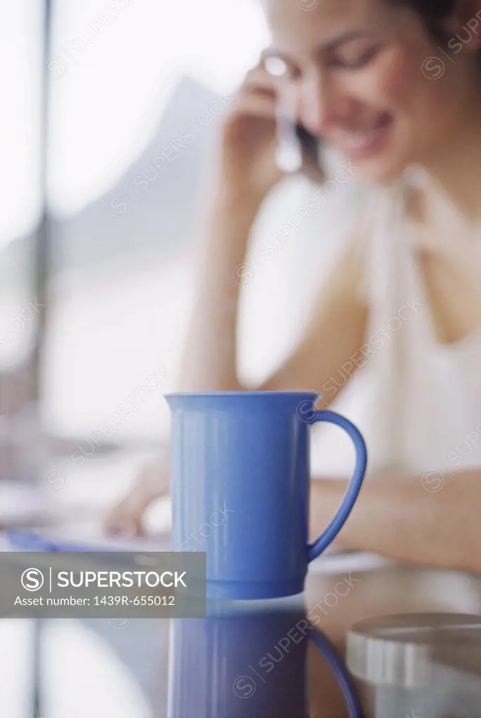 Woman on mobile phone with coffee cup