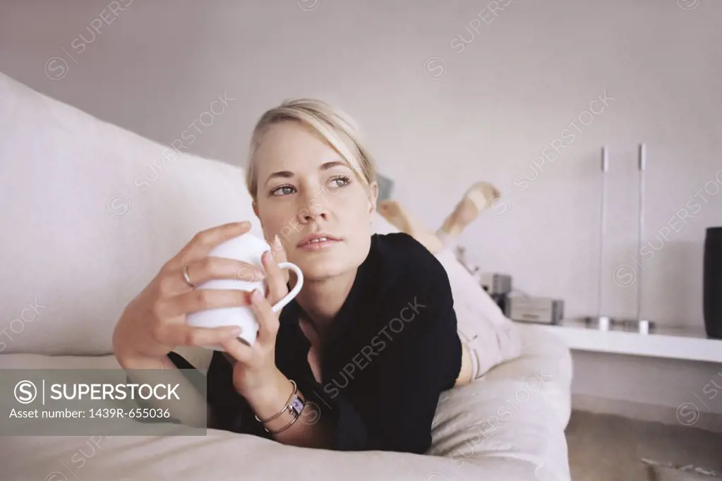 Woman relaxing on the sofa with a drink