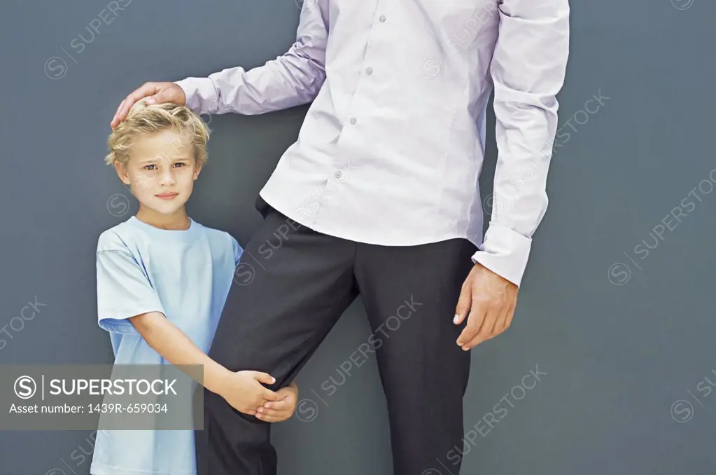 Boy holding his father's leg