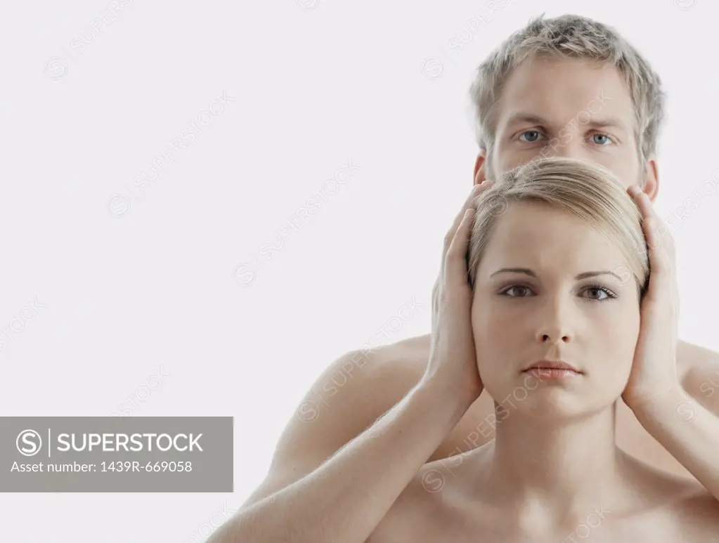 Man covering woman's ears
