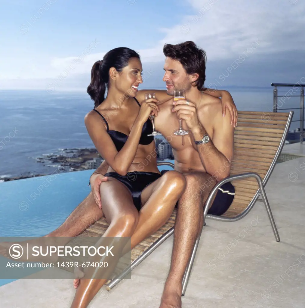 Couple on a sunlounger with champagne