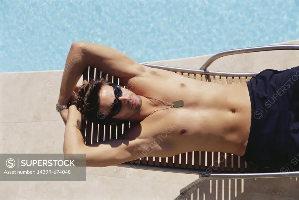 Man sunbathing by the pool