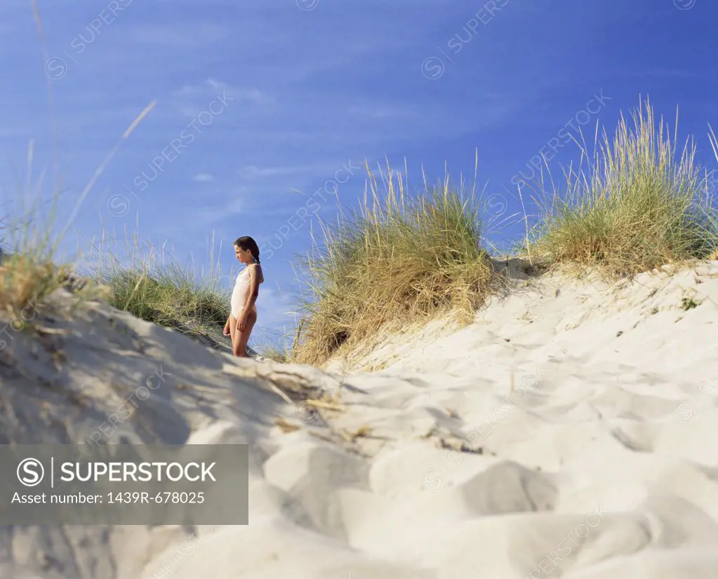 Girl standing in a sand dune