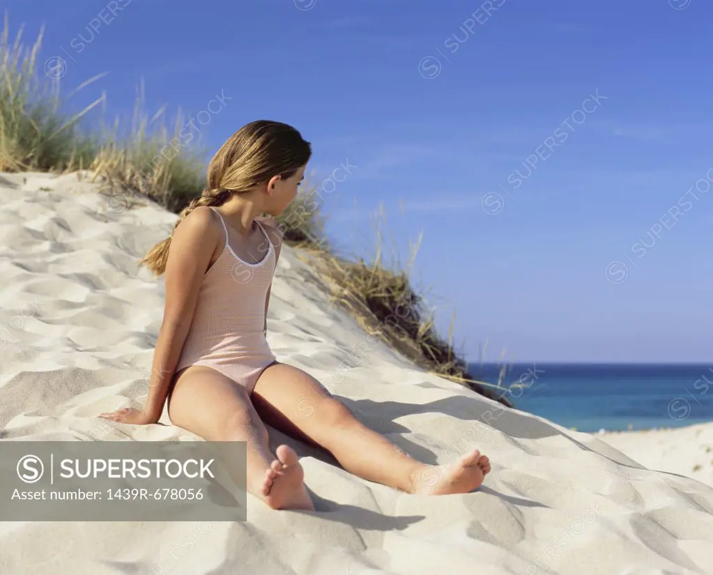 Girl sitting on a sand dune
