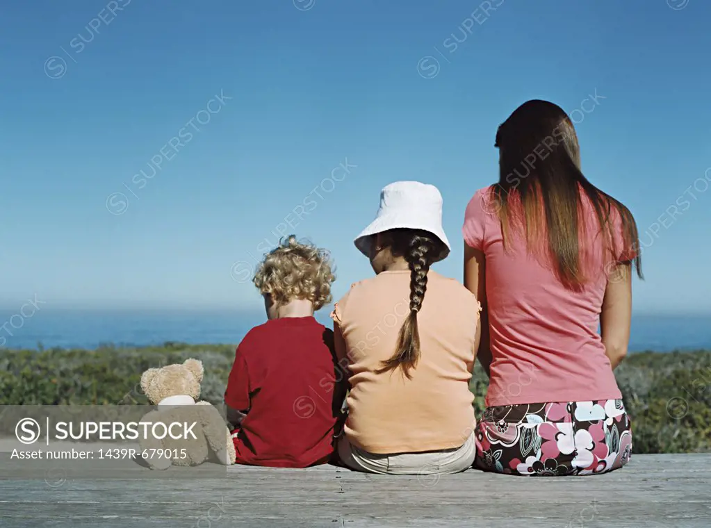 Mother and children sitting on deck