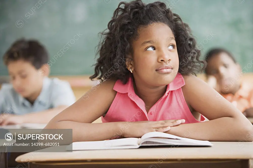 Schoolgirl daydreaming in classroom