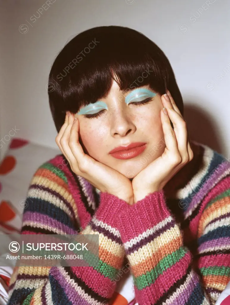 Woman with eyes closed wearing bright eyeshadow
