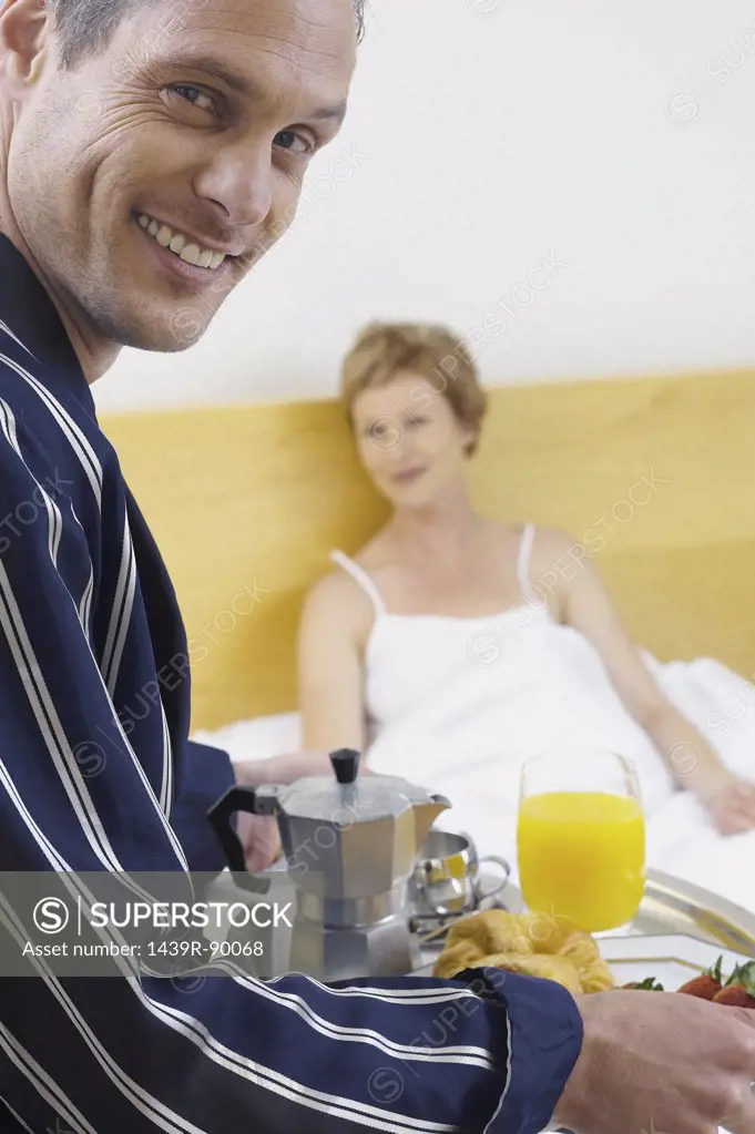 Man delivering breakfast in bed